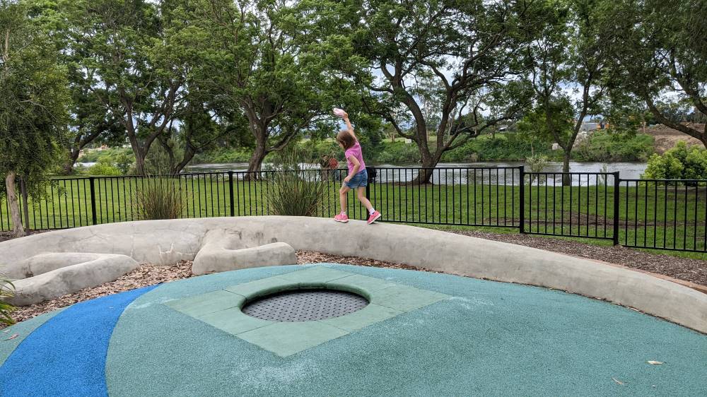 girl walking on large balance lizard and trampoline at Governor Phillip Park Windsor