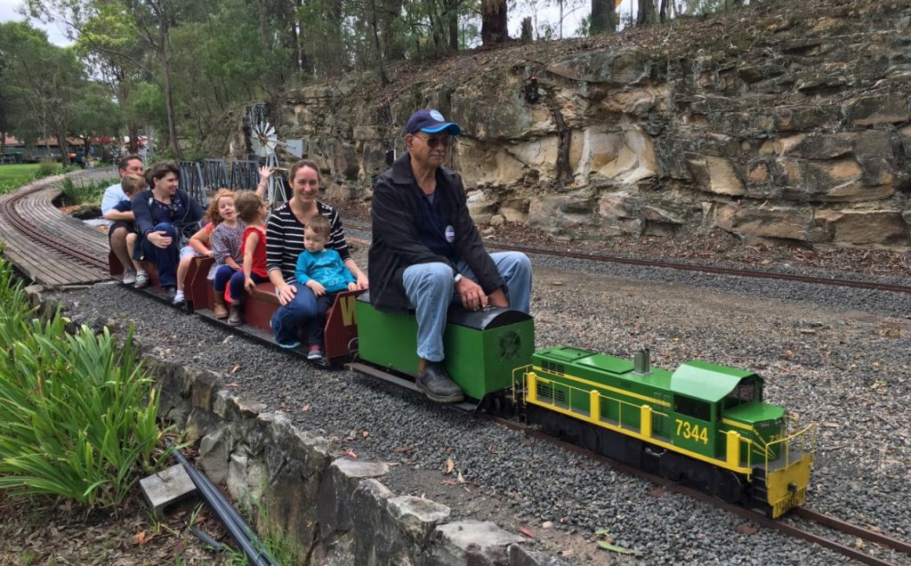 Blue Mountains Winter School Holidays Activities Guide 2023 Wascoe Siding Man  driving miniature train with 8 passengers