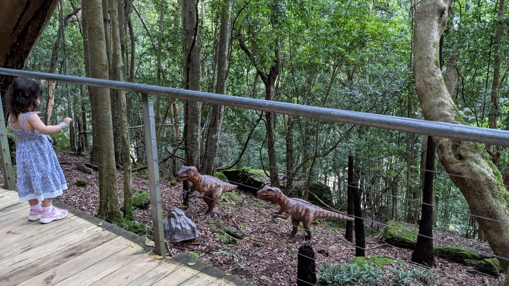 little girl meeting two dinosaurs at dinosaur valley scenic world