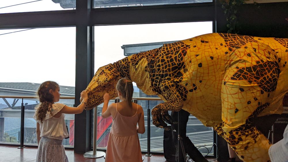 two young girls meeting a dinosaur at raptor tales scenic world