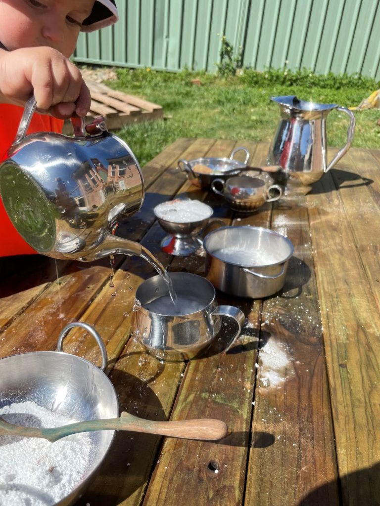 mountain kids sensory play pouring water from a teapot