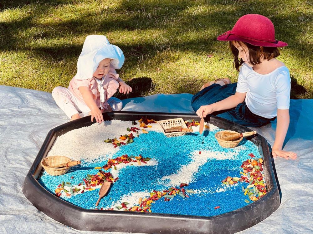 mountain kids sensory play two girls playing with blue rice