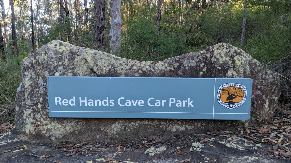 red hands cave carpark sign