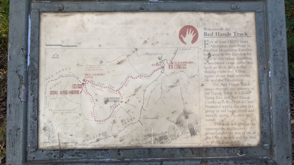 sign at red hands cave explaining the history of the Darak people
