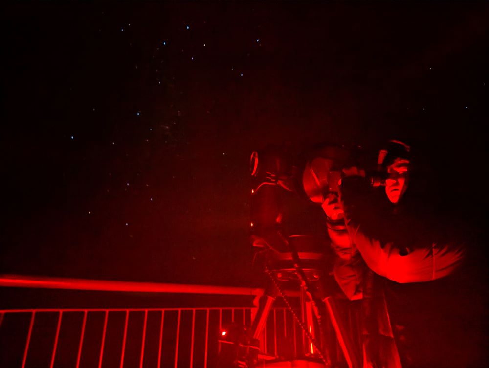 A young boy looking through the telescop at the stars on a Blue Mountains Stargazing tour