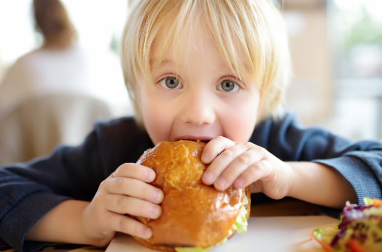 boy eating a large hamburger where kids eat free in the blue mountains, penrith and richmond