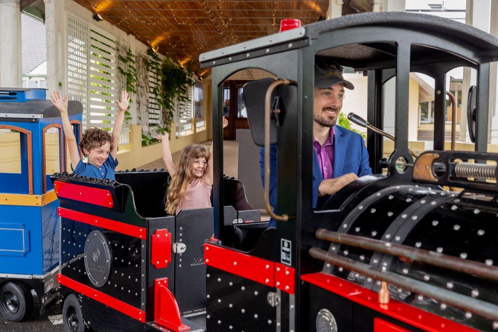 Fairmont Resort's Christmas School Holidays Program 2023 two kids wioth hands up on the train